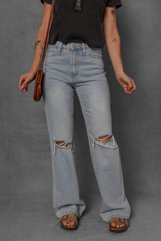 women modeling light wash denim jeans with distressed knees