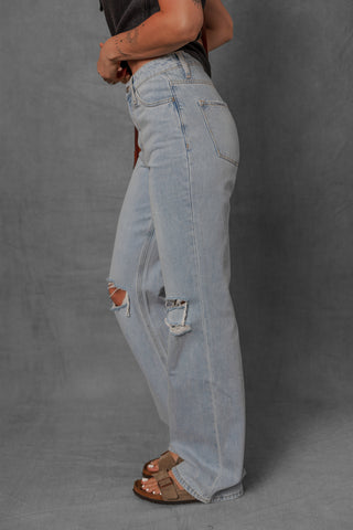 women modeling light wash denim jeans with distressed knees